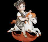Фарфоровая кукла "Мальчик сидящий на лошадке-качалке", Sibania